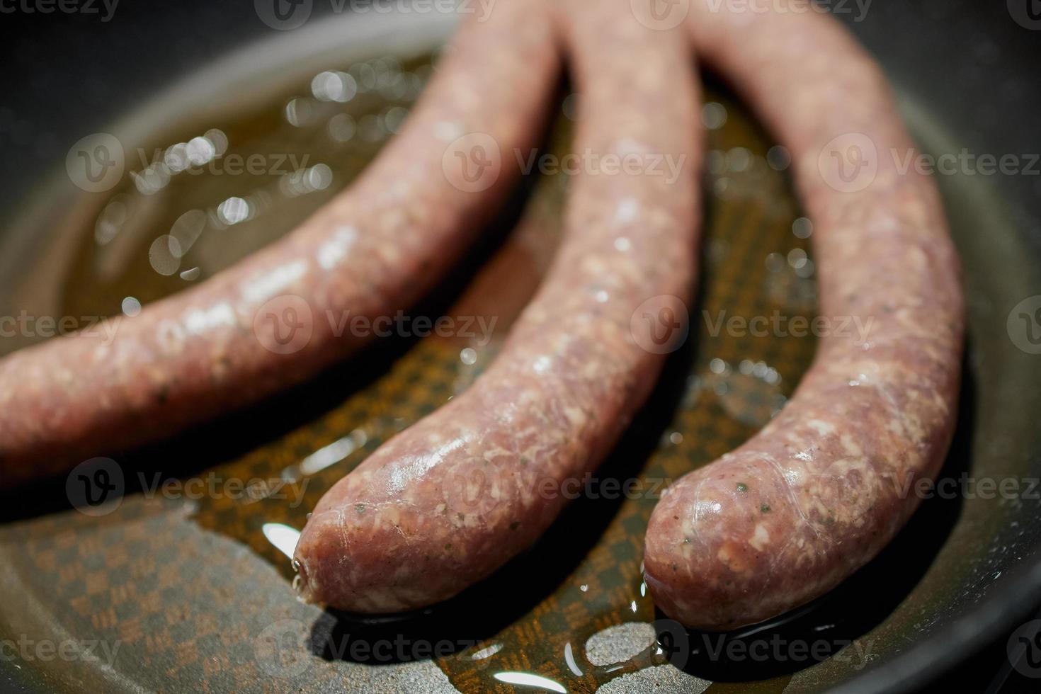 närbild av tysk bratwurst i en panna foto