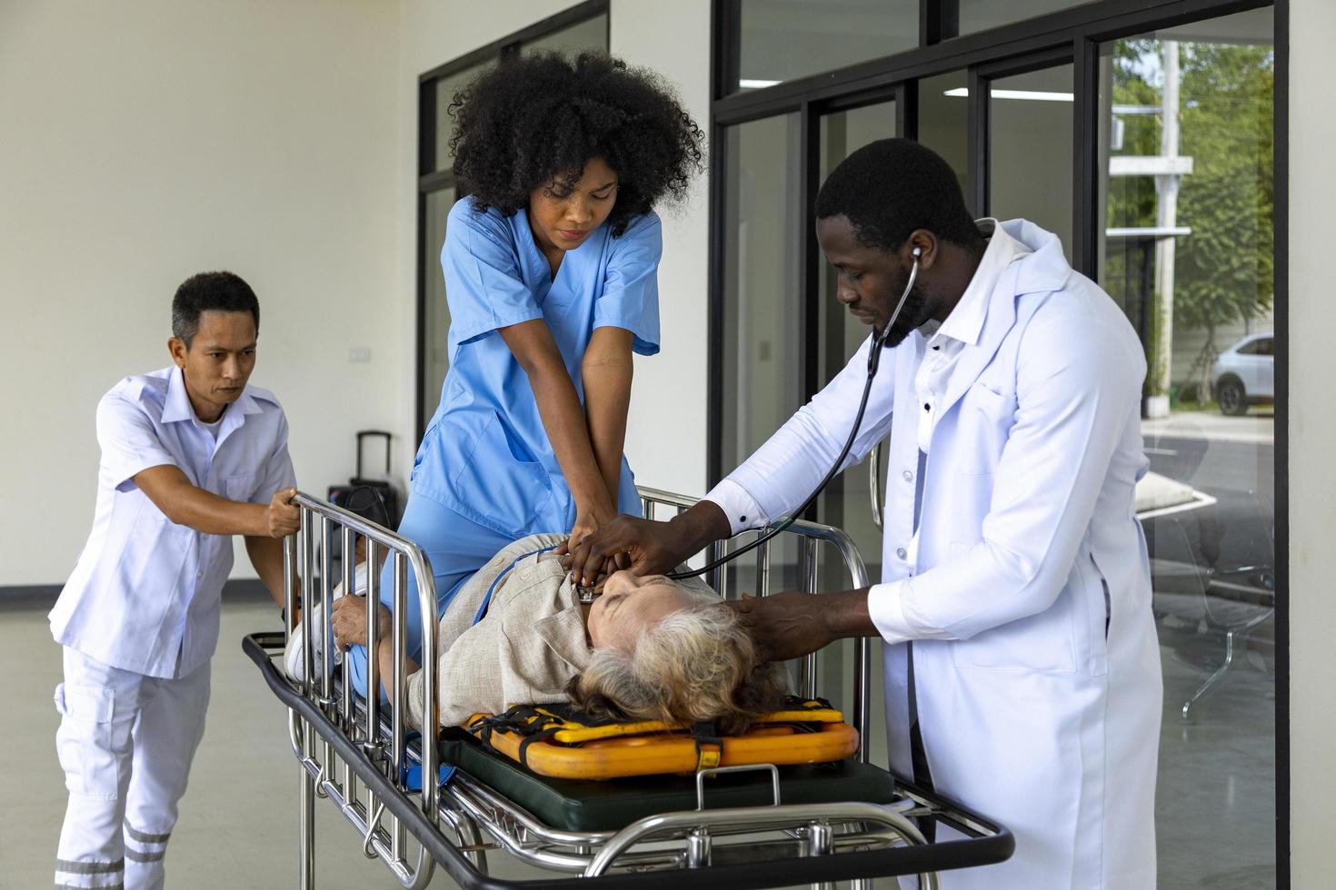 sjuksköterska utför hjärt-lungräddning för patient med hjärtinfarkt i sängen medan hon rusar mot akutenheten på sjukhuset från ambulans för ambulans och livräddningskoncept foto