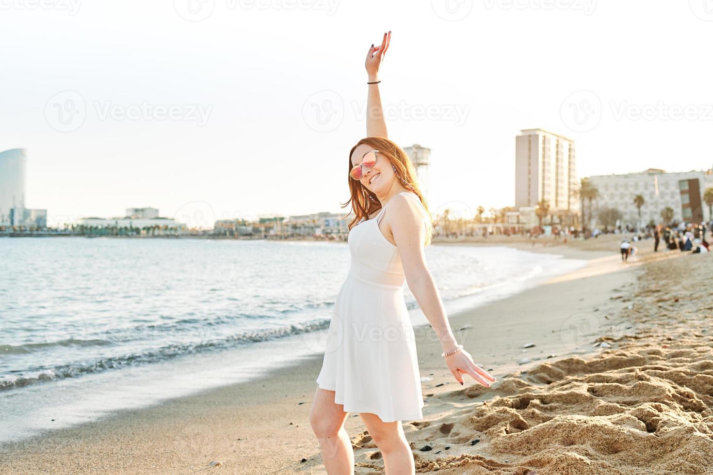 en glad rött hår flicka på stranden foto
