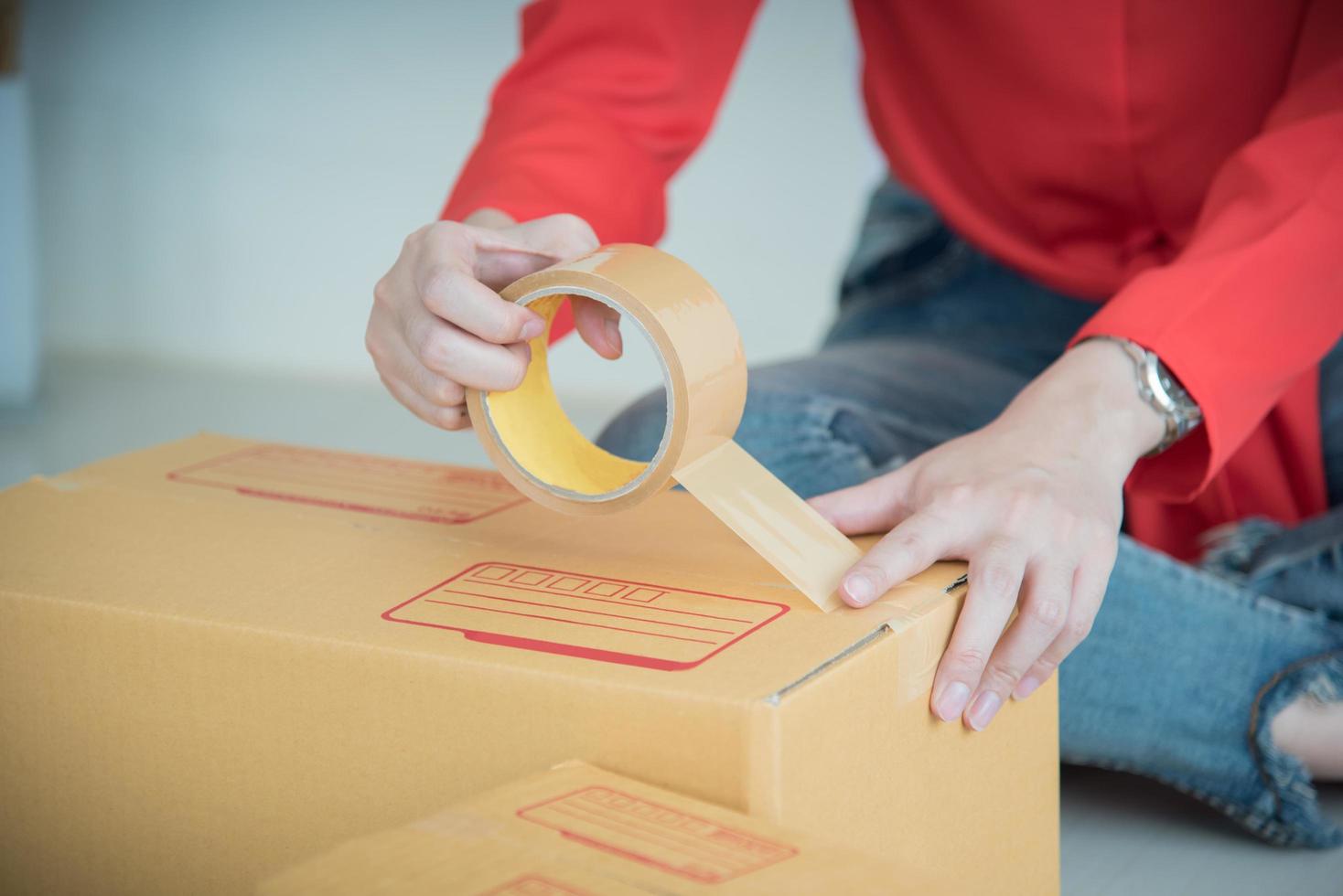 unga kvinnor förbereder ett paket för leverans till kunder. foto