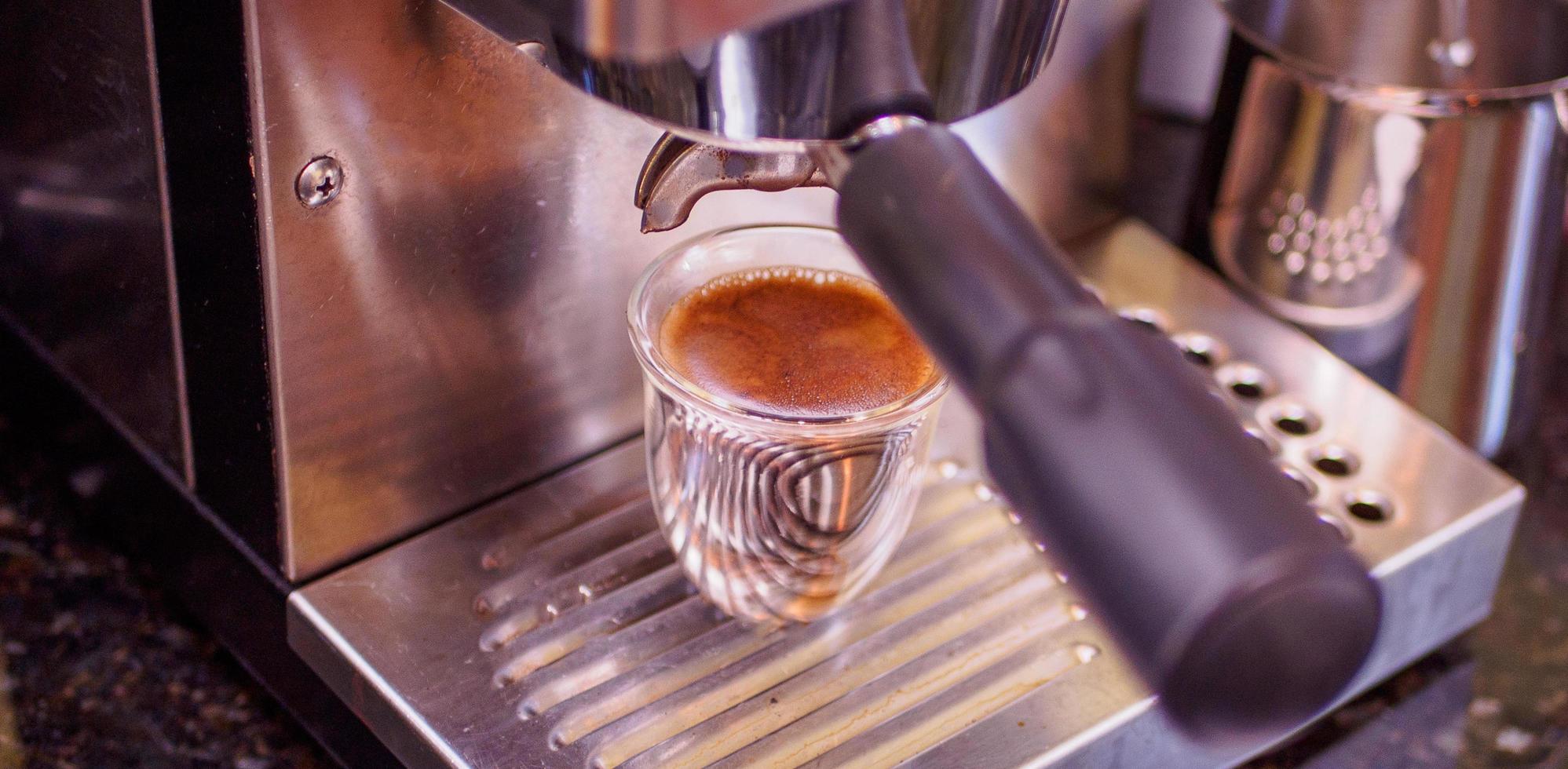 nybryggd espresso brunt guld på en espressomaskin av stål foto