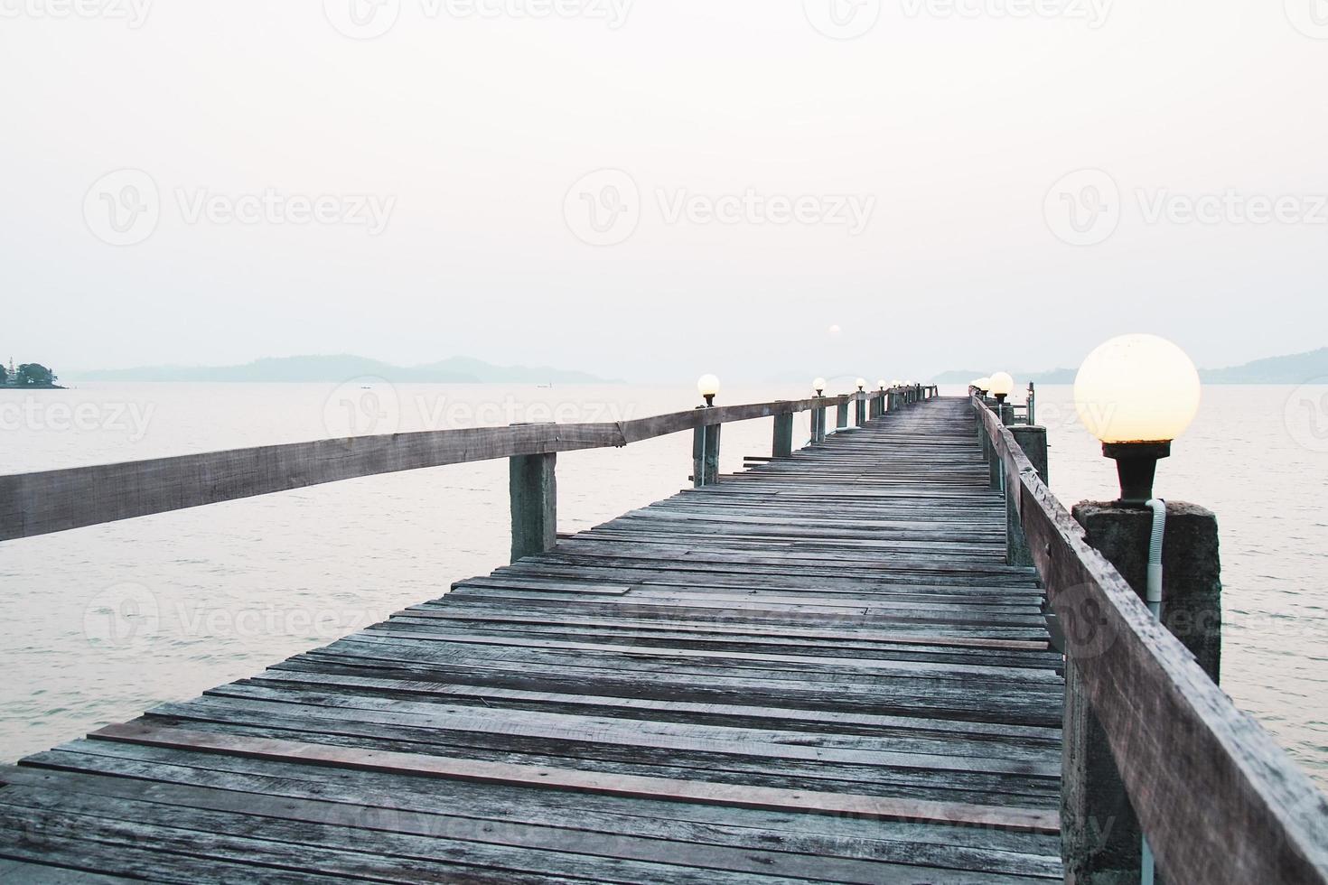 en gångväg i trä som sträcker sig ut i havet. semester resor koncept foto