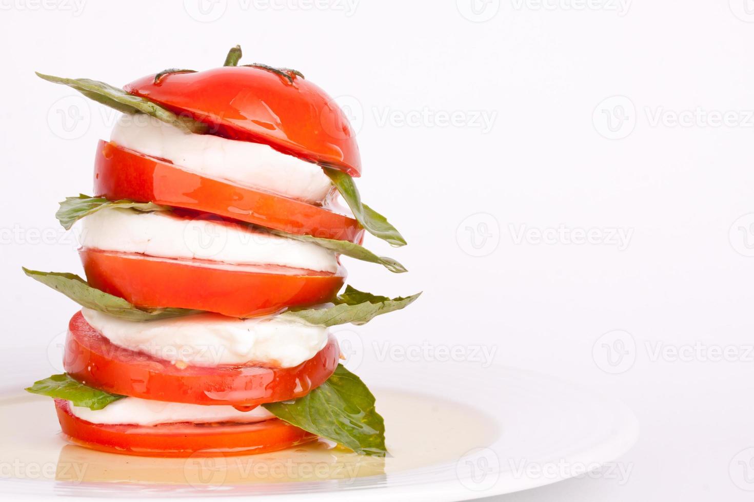 caprese sallad med mozzarella, tomat och basilika foto