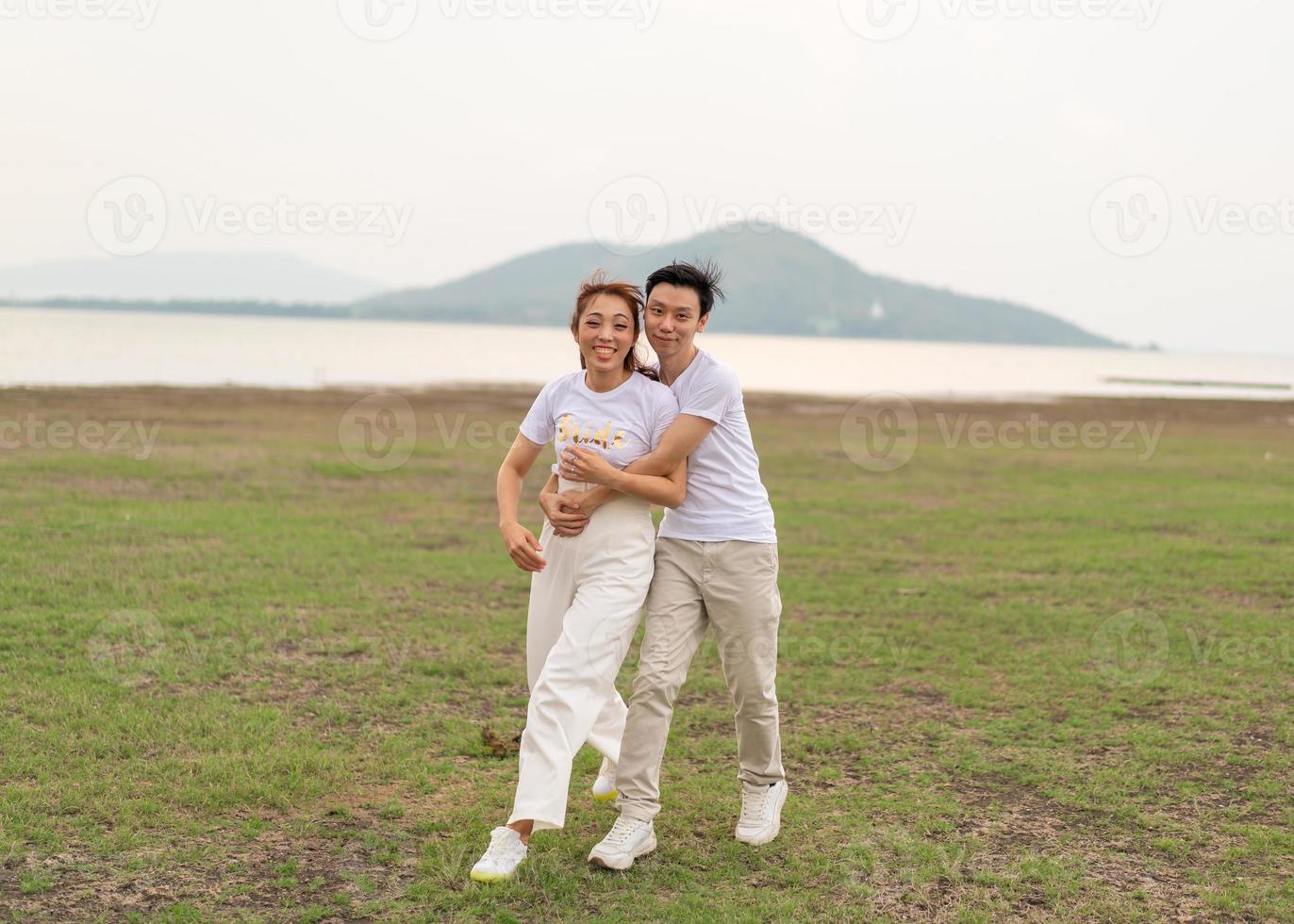 glada unga asiatiska par i brud och brudgum t-shirt foto