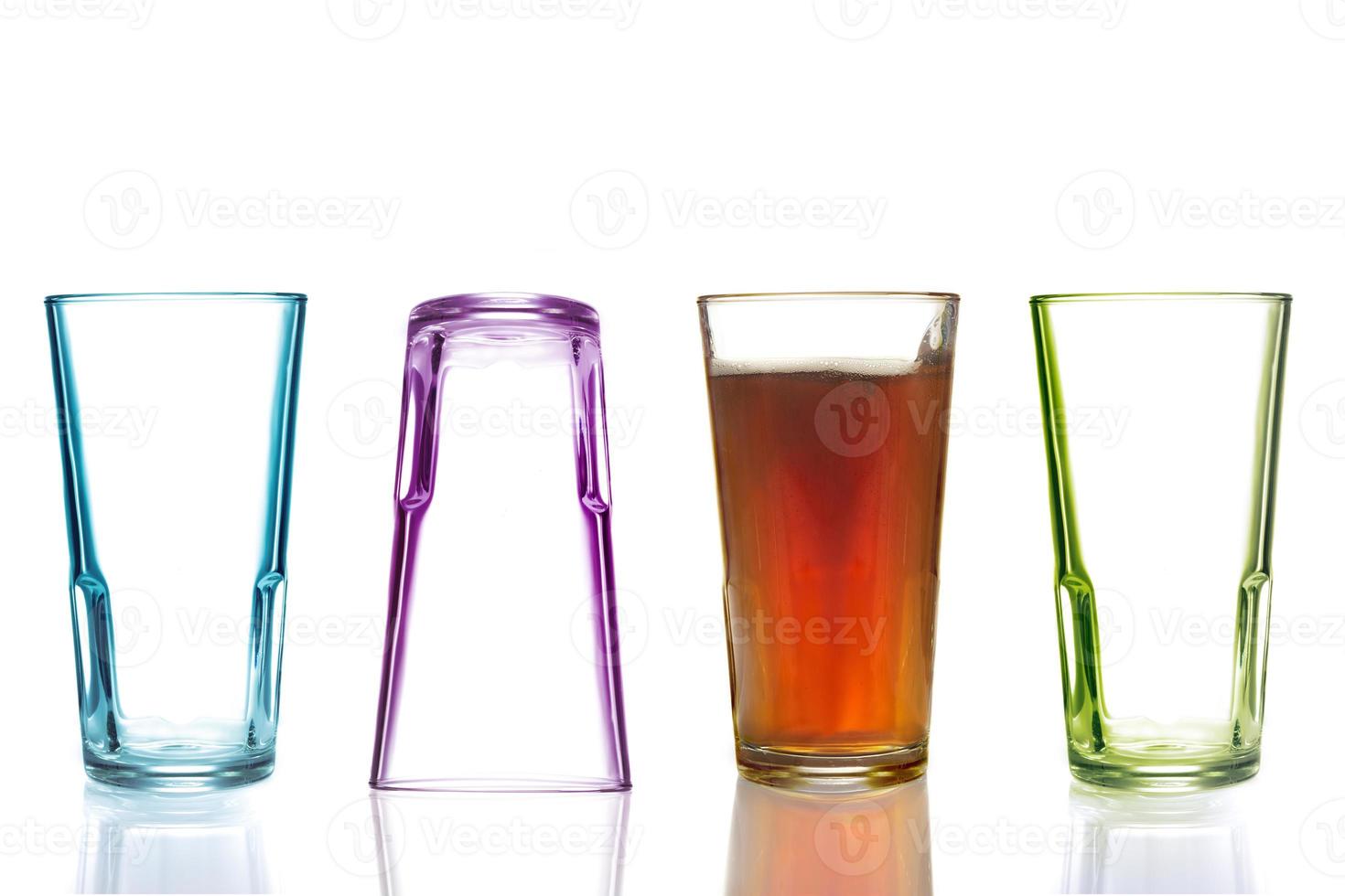 fyra färgglada dricksglas, ett med cola foto