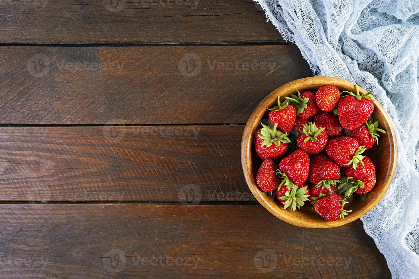 söt färsk mogen jordgubbe isolerad på trä bakgrund. foto