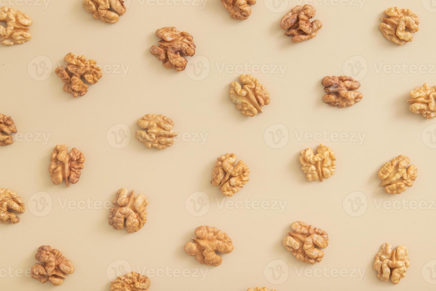 mönster med skalade halvor av valnötter ovanifrån. mat abstrakt bakgrund med nötter foto