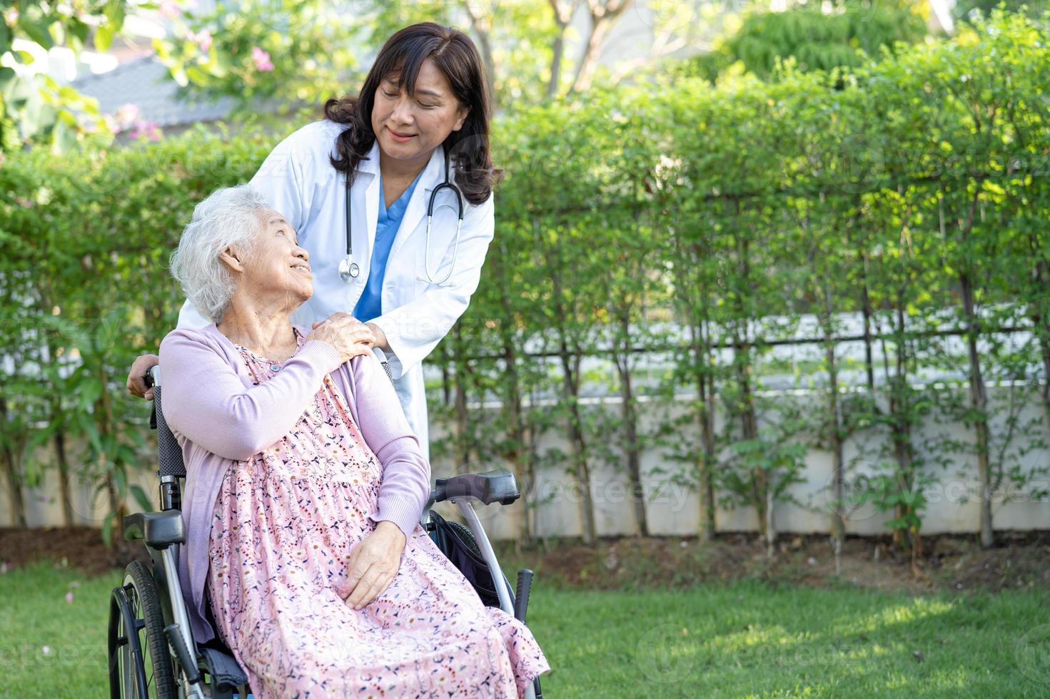 läkarehjälp och vård asiatisk senior eller äldre gammal damkvinnapatient som sitter på rullstol på parkerar på vårdavdelningen, hälsosamt starkt medicinskt koncept. foto