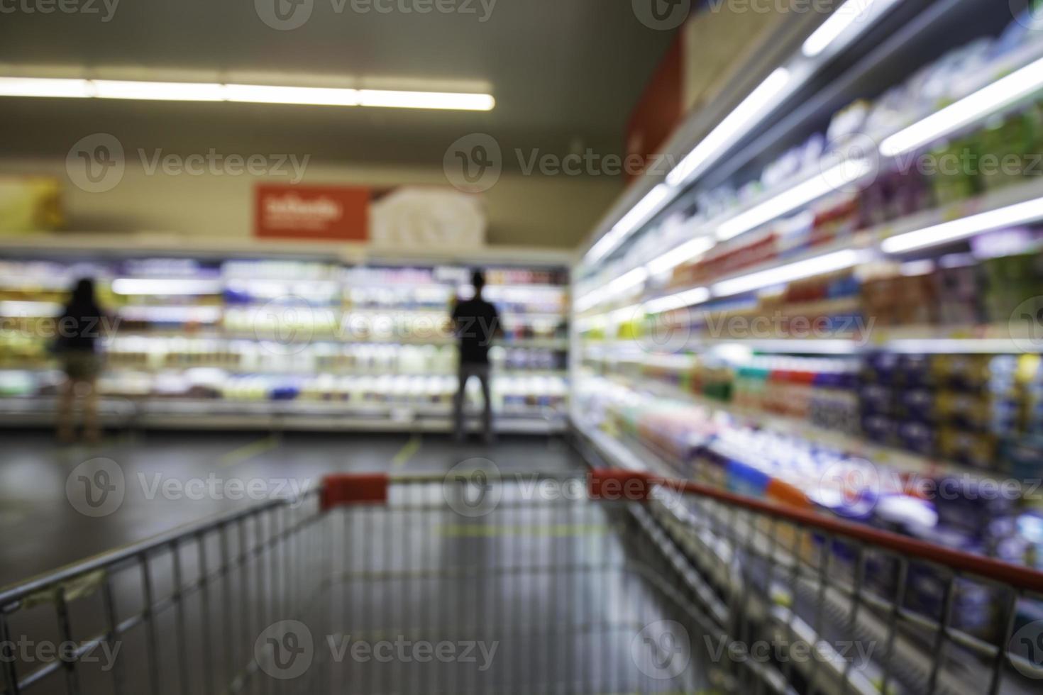 den oskärpa oskärpa av dryck mjölk mat köpa kundvagn shopping ställa på en hylla vid drinken foto