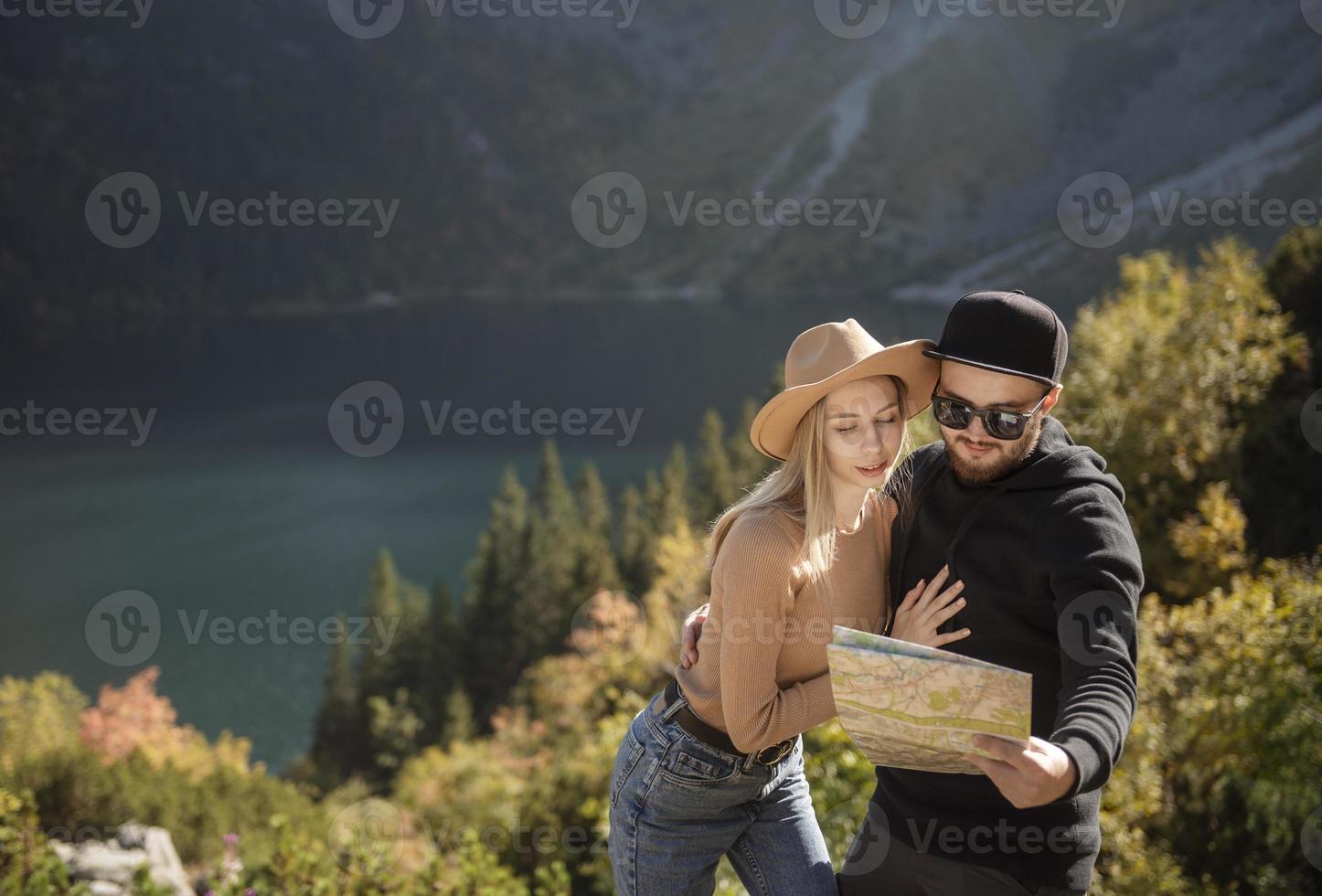 unga turist par, man och kvinna, på vandringsled i bergen foto
