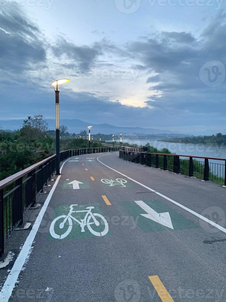 gågata vid floden med cykelbana i gryningen foto