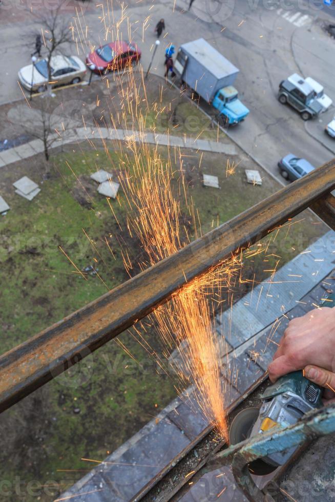 en arbetare skär metall med en kvarn. foto
