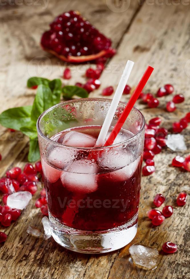 färsk röd juice cocktail med granatäpplefrön, mynta och is foto