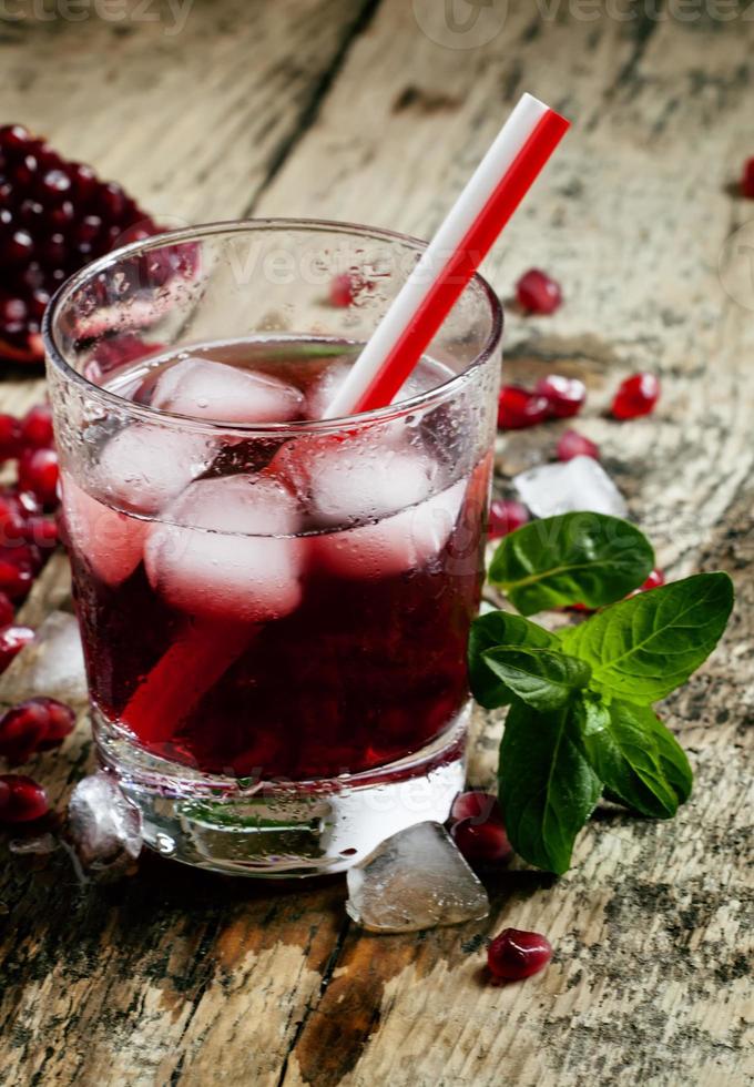 färsk röd juice cocktail med granatäpplefrön, mynta och is foto