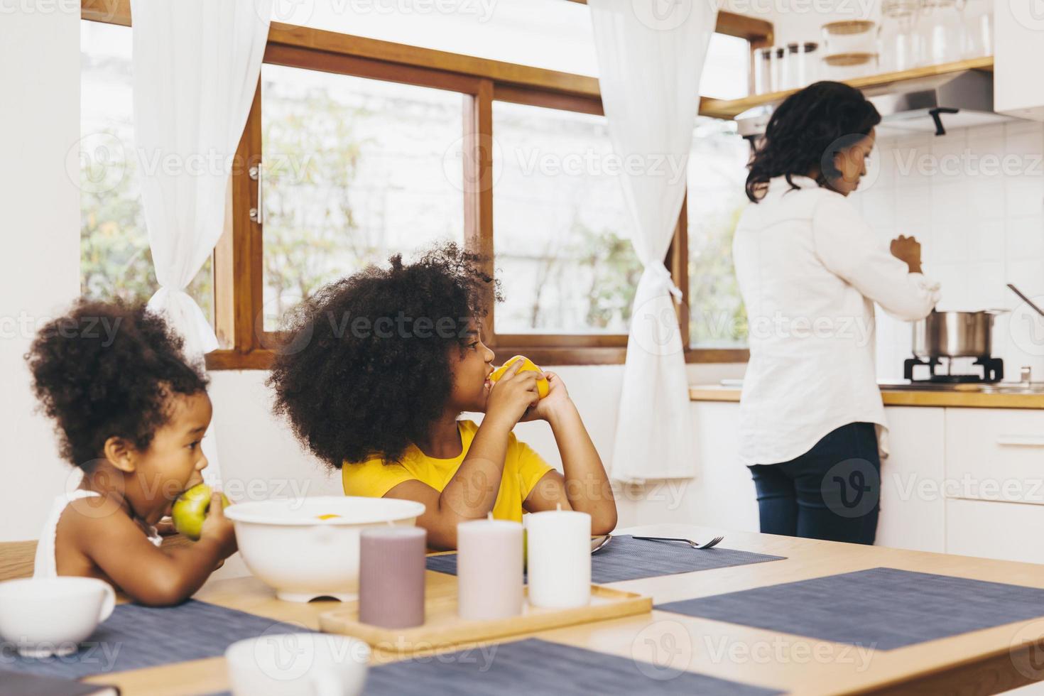 mamma lagar mat till sina två barn som väntar på lunch. ensamstående mamma koncept. foto