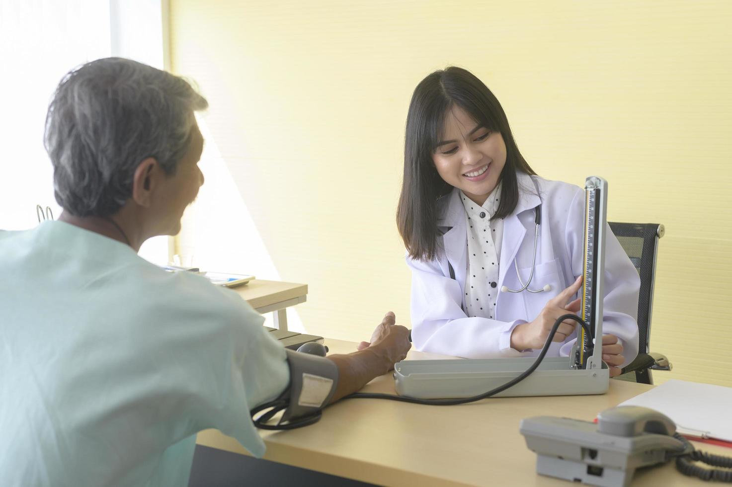 asiatisk senior manlig patient konsulterar och besöker läkare på sjukhus.. foto