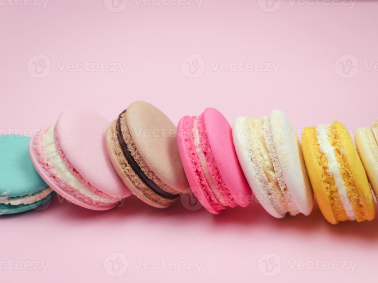 färgglada franska macarons macaroons tårta, utsökt söt dessert på en rosa bakgrund med copyspace, mat bakgrund koncept. foto