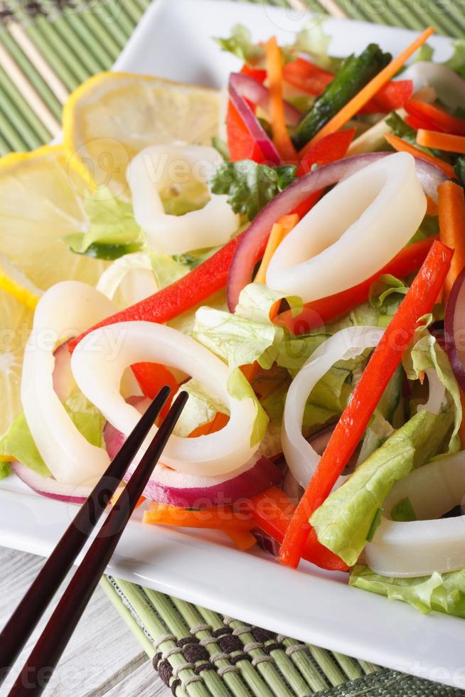 japansk sallad med grönsaker och bläckfisk närbild vertikal foto