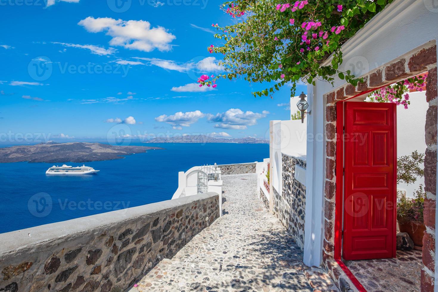 fantastiska resor bakgrund, santorini stadslandskap. röd dörr eller grind med trappor och vit arkitektur under blå himmel. idyllisk sommarsemester semester koncept. underbara sommarlyxvibbar foto