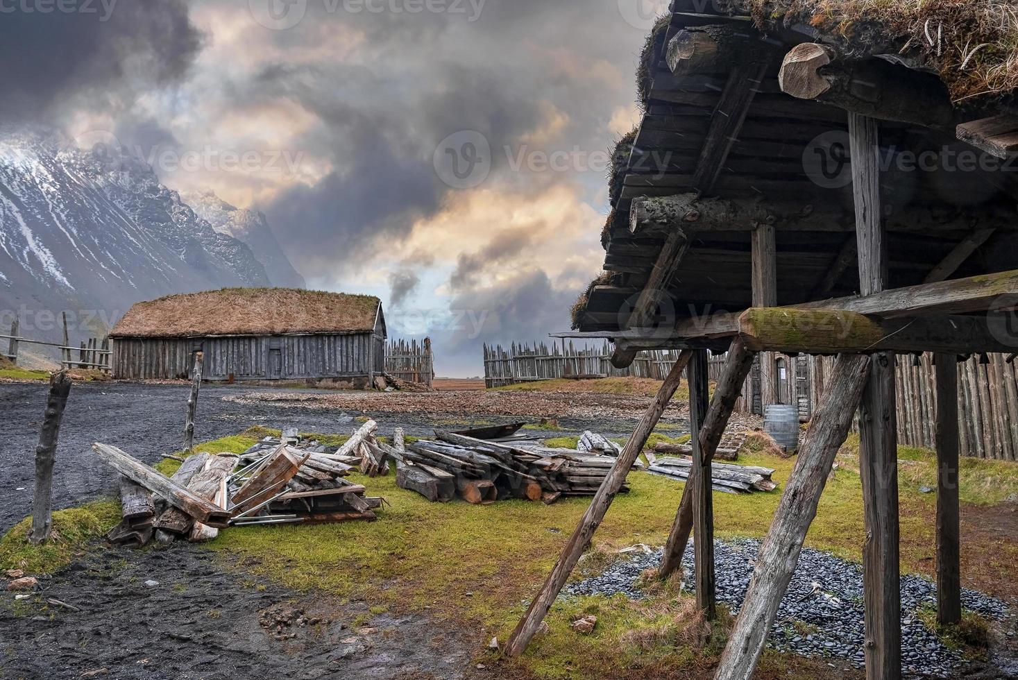 stockar vid skjul och traditionella hus omgivna av staket i gammal vikingaby foto