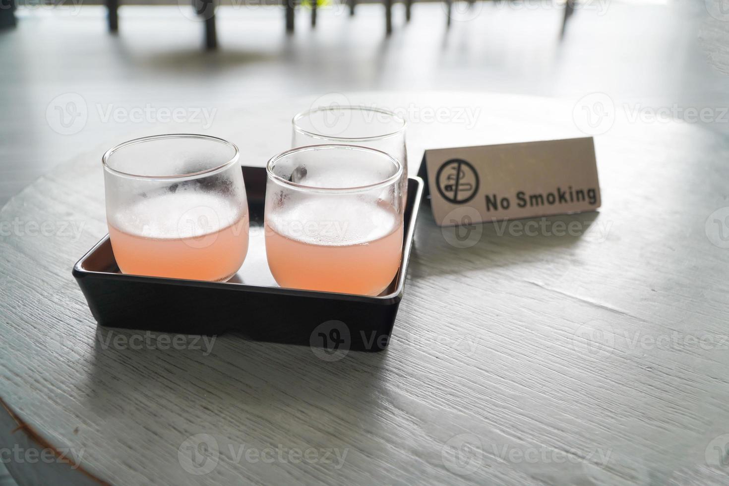 litchi blandad med persikojuice i glas på träbord uppfriskande drink på sommaren, välkomstdrink foto
