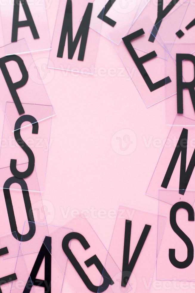 ram av engelska bokstäver med kopia utrymme på pastell rosa bakgrund. alfabetstudie, abc, utbildning eller affärsidé. toppvy. närbild. foto