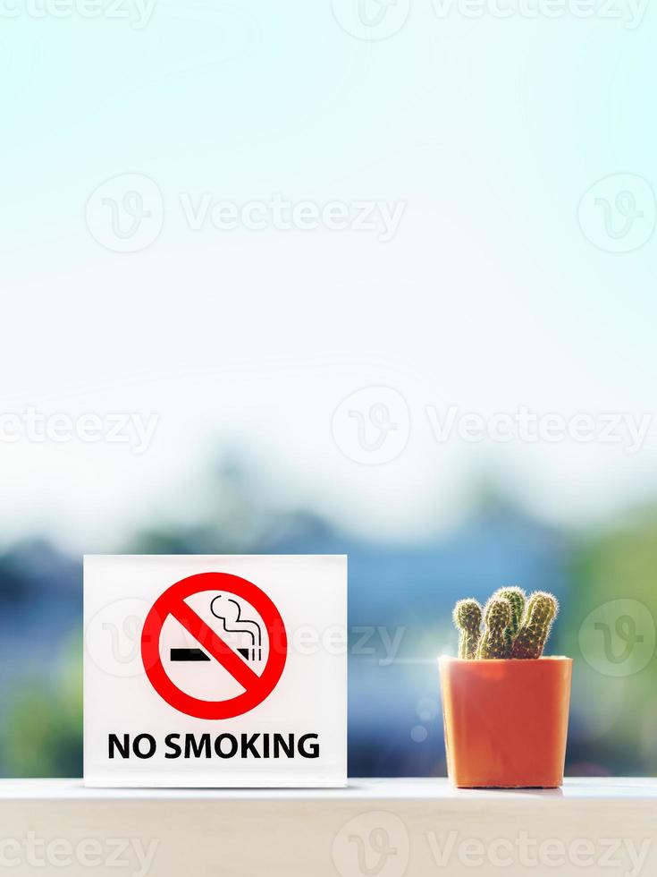 ingen rökning skylt i hotellrum med kaktus på träbord. foto