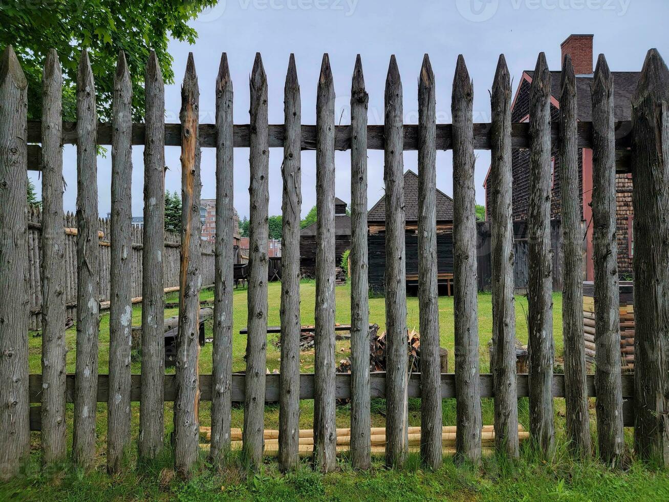 skarpt trästaket eller vägg med fort med gräs foto