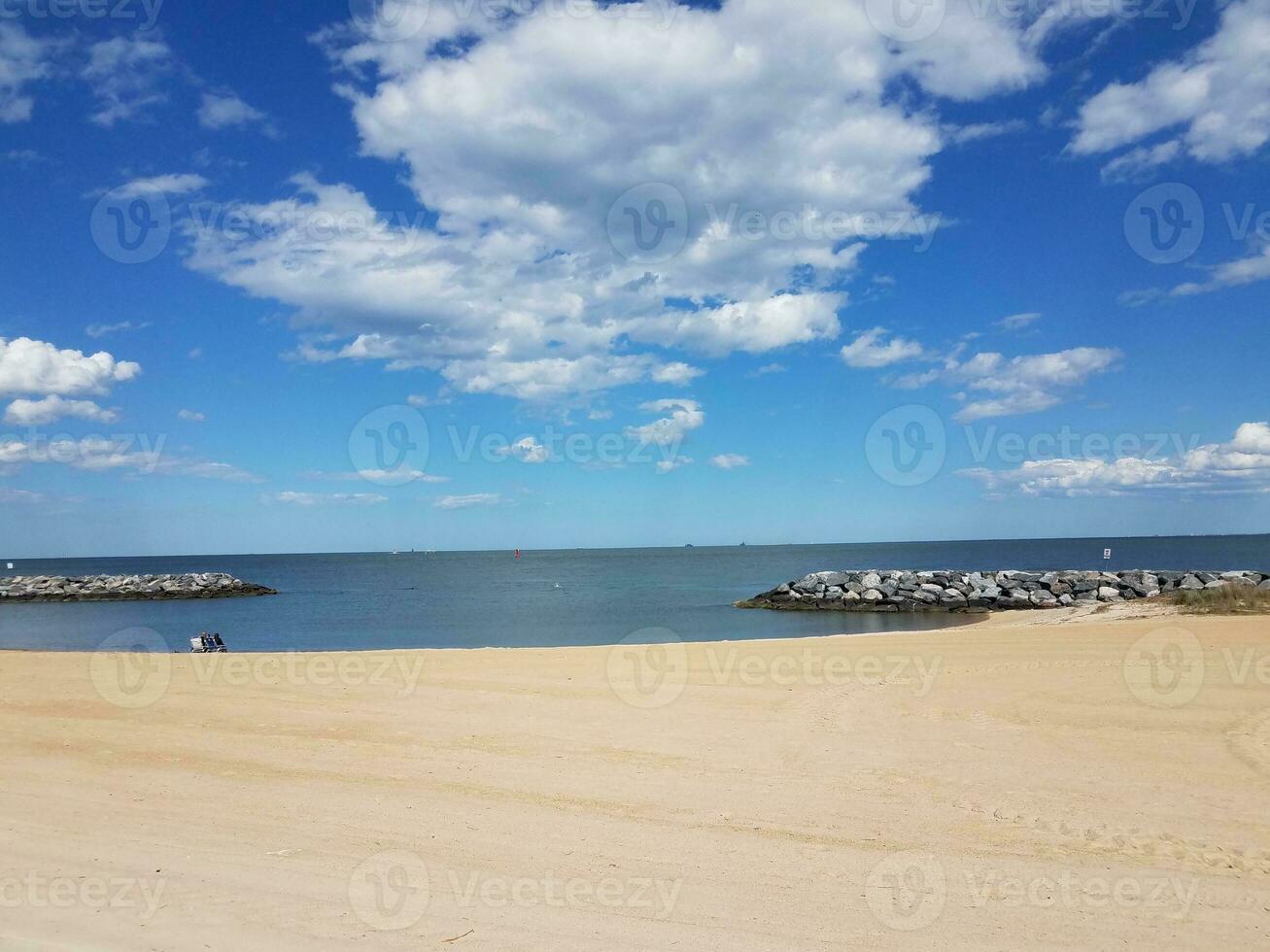 sand och stenar och vatten och moln på stranden foto