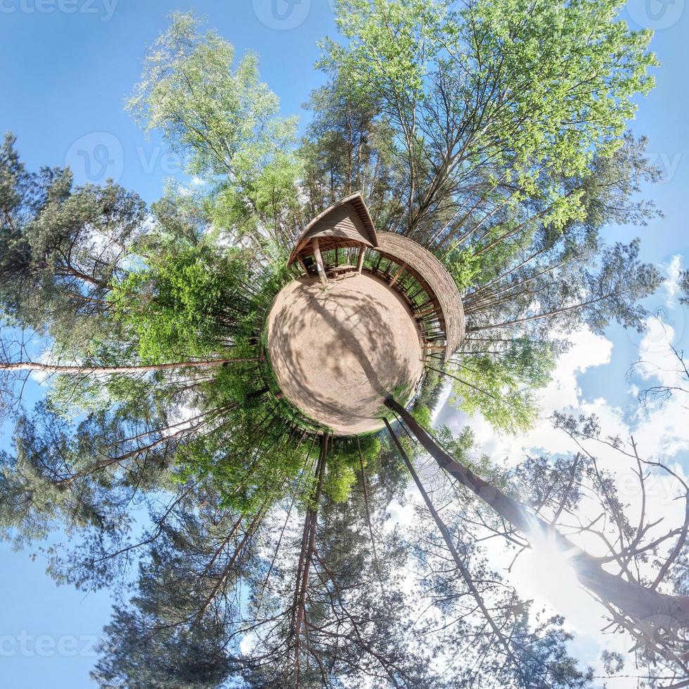 liten planet. sfärisk flygfoto i skog nära fritidshus i trevlig dag med fina moln foto