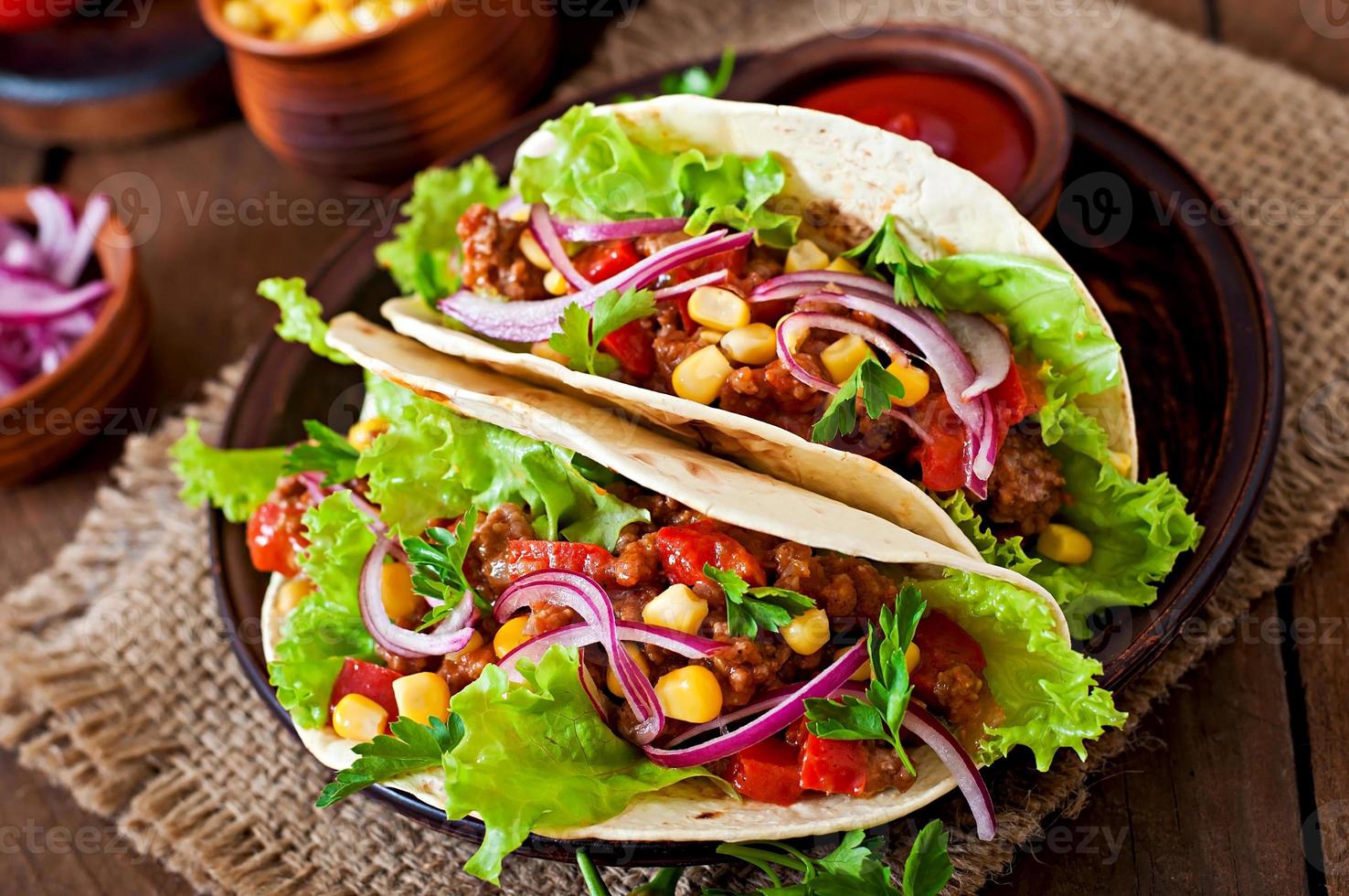 mexikansk tacos med kött, grönsaker och rödlök foto