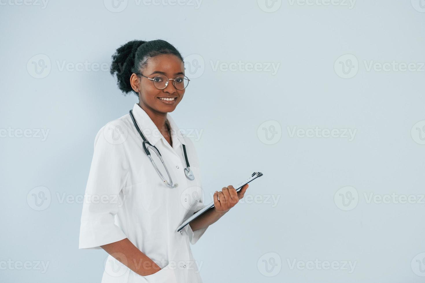 ung afroamerikansk läkare är mot vit bakgrund foto