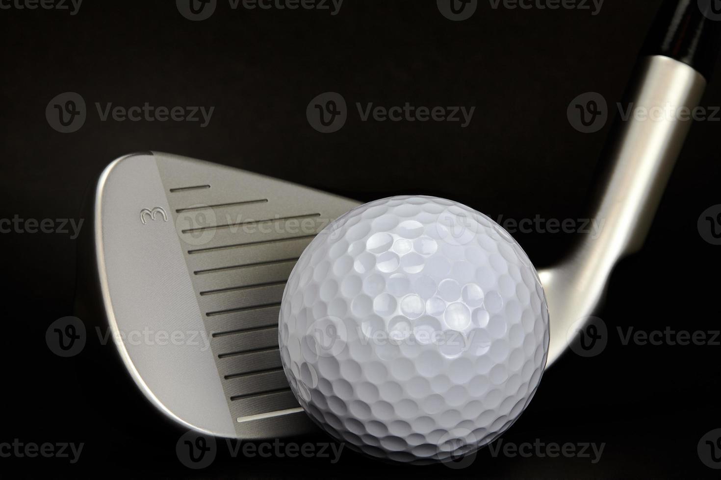 golfboll och klubb närbild på svart bakgrund foto