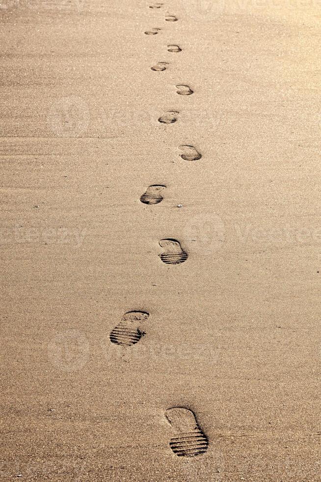 närbild av fotspår i sanden på stranden foto