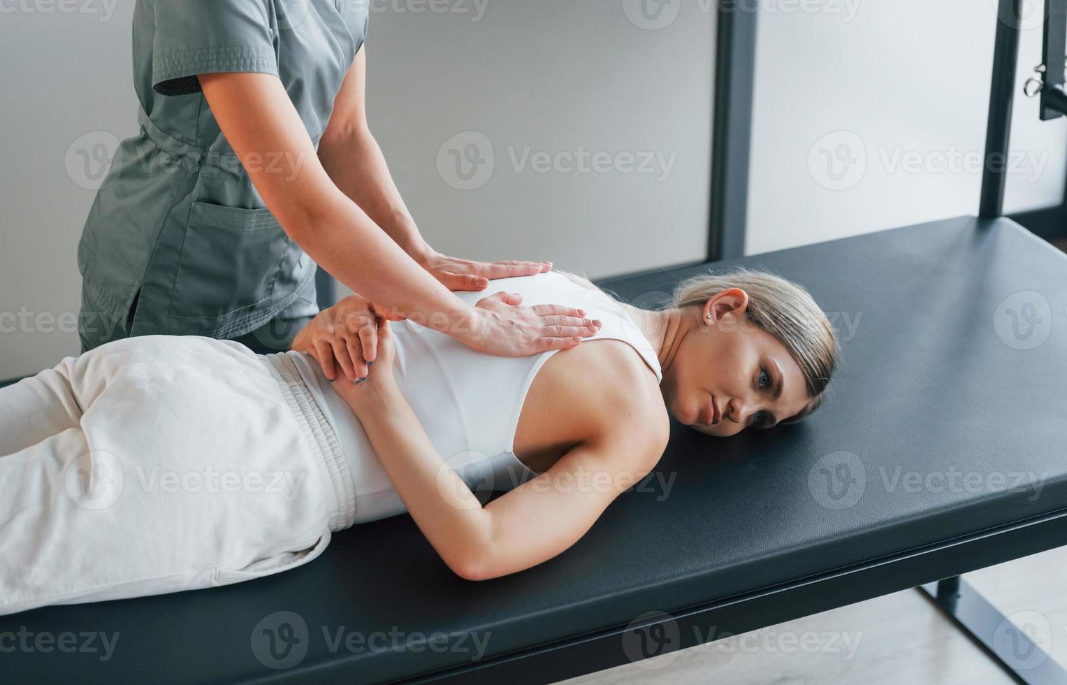 professionell massage. kvinna är på vårdcentral och får hjälp av läkare foto