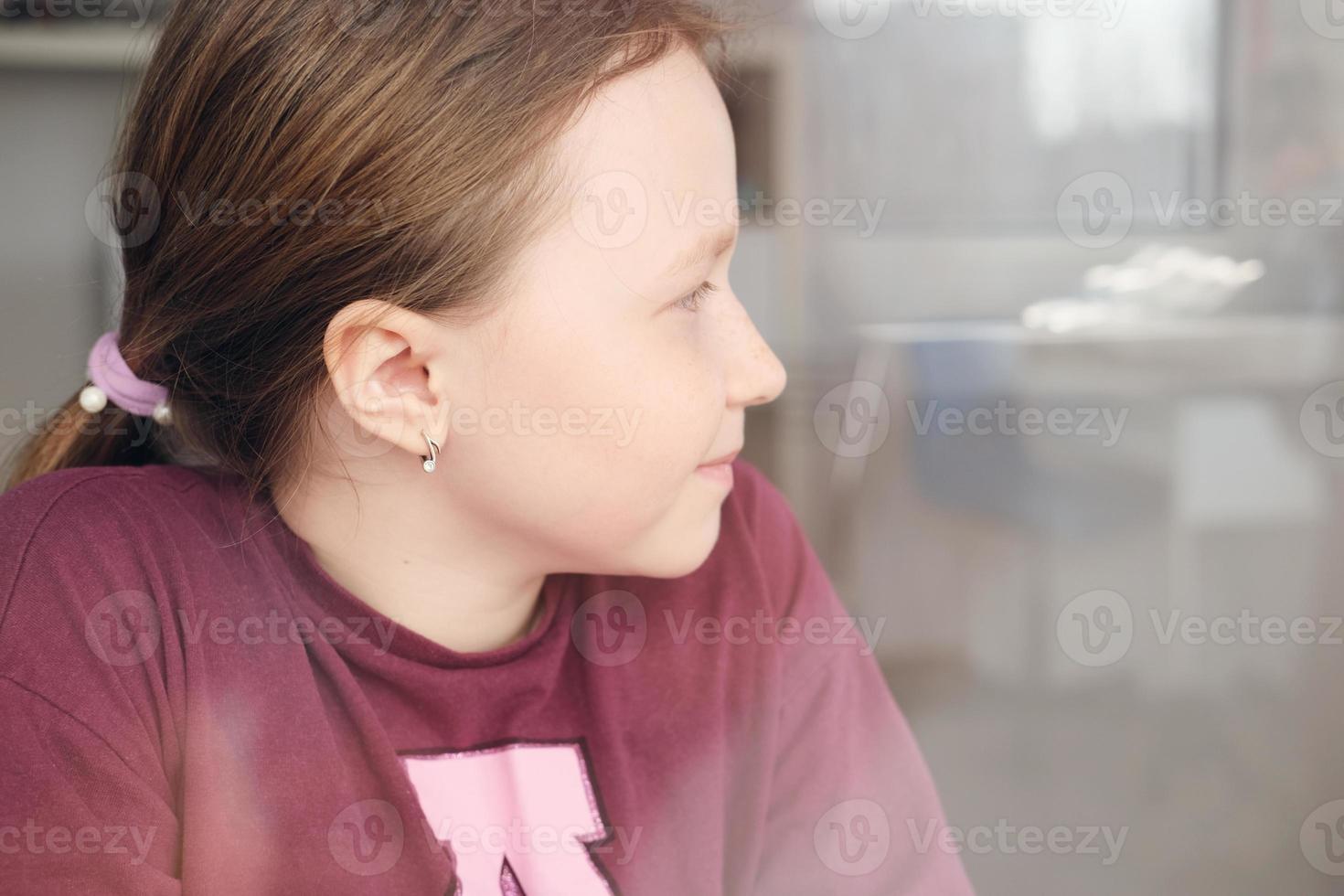 vacker tonårsflicka tittar genom fönstret. foto