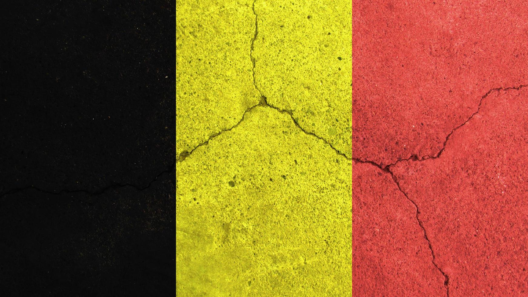 Belgiens flagga. Belgiens flagga på sprucken betongvägg foto