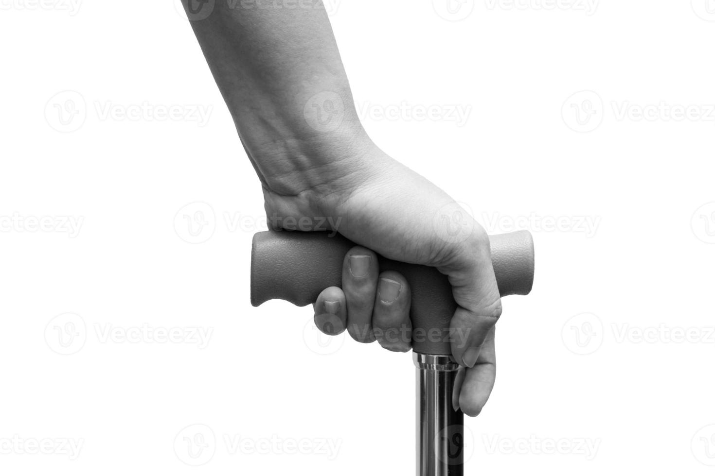 närbild av hand som håller en käpp eller käpp, isolerad på vit bakgrund. medicinsk och hälsovård koncept. svart och vit ton foto