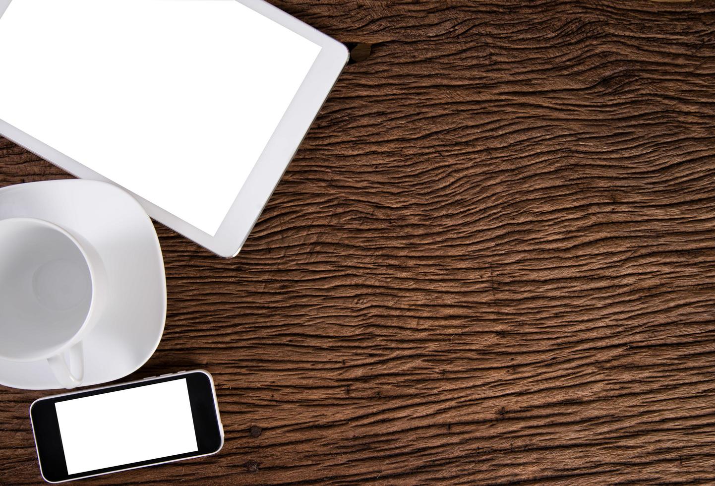 digital surfplatta och vit smart telefon med emtry kopp kaffe på gammal trä bakgrund foto