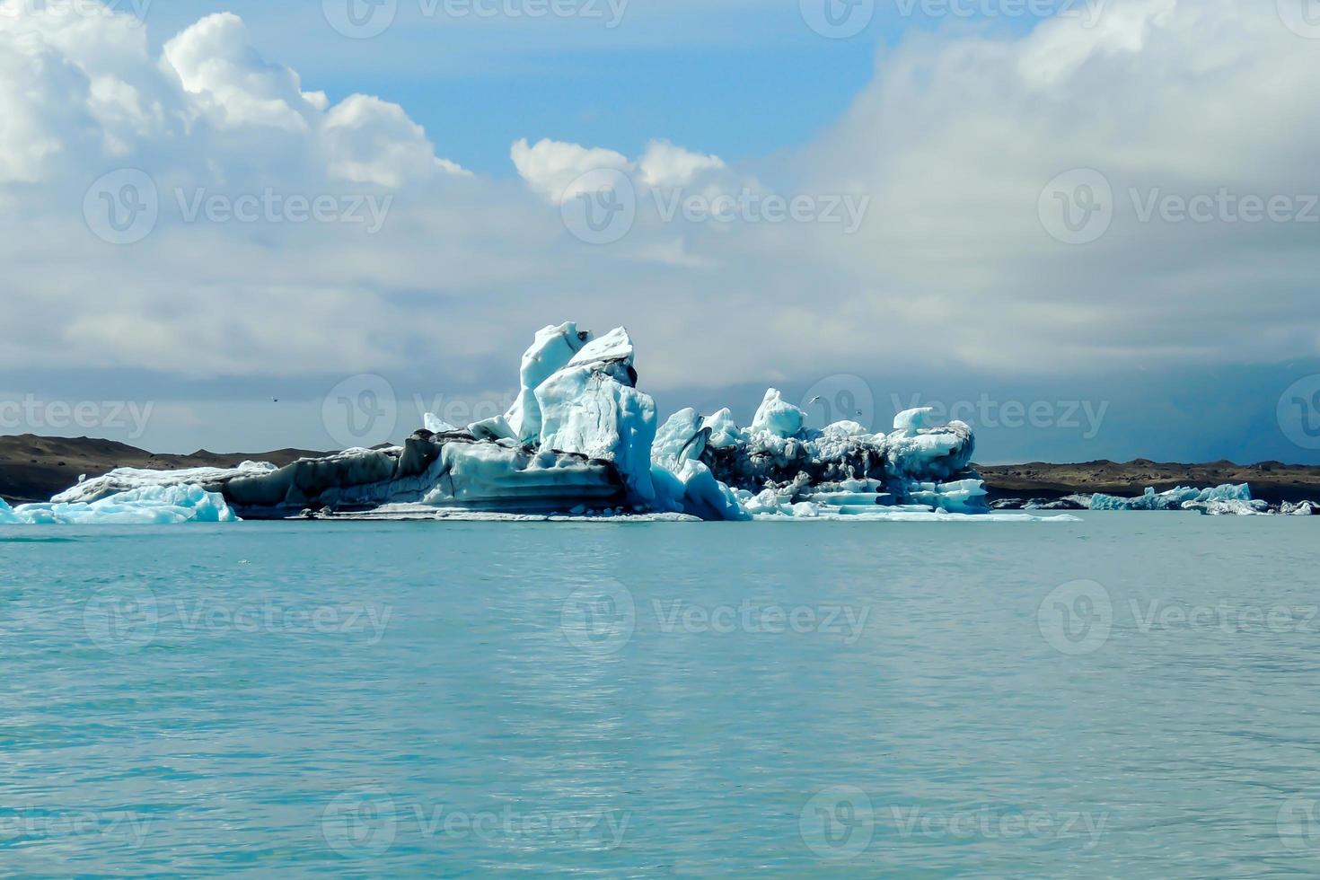 klarblått isberg som flyter i sjön jokulsarlon blått kallt vatten på Island 26 foto