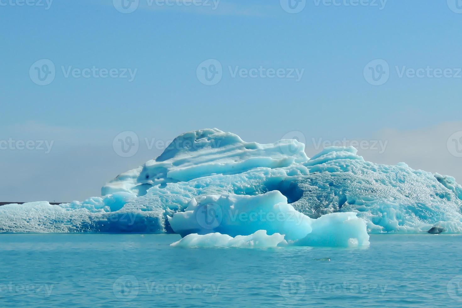 klarblått isberg som flyter i sjön jokulsarlon blått kallt vatten på Island 3 foto