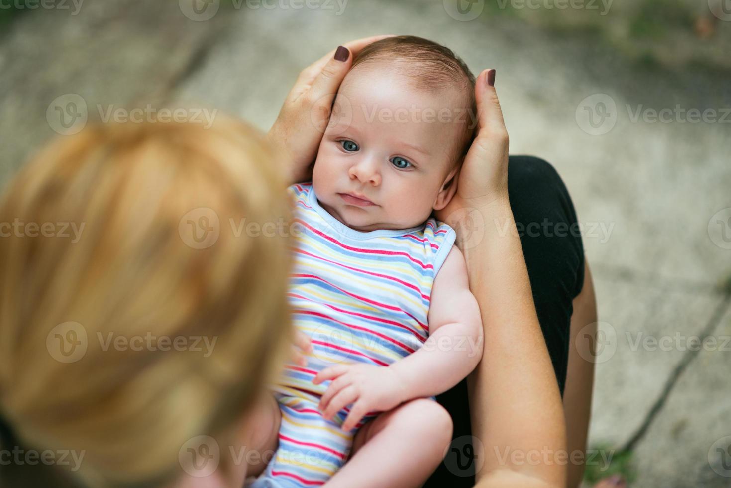 kärleksfull mamma som håller barnet i knät foto