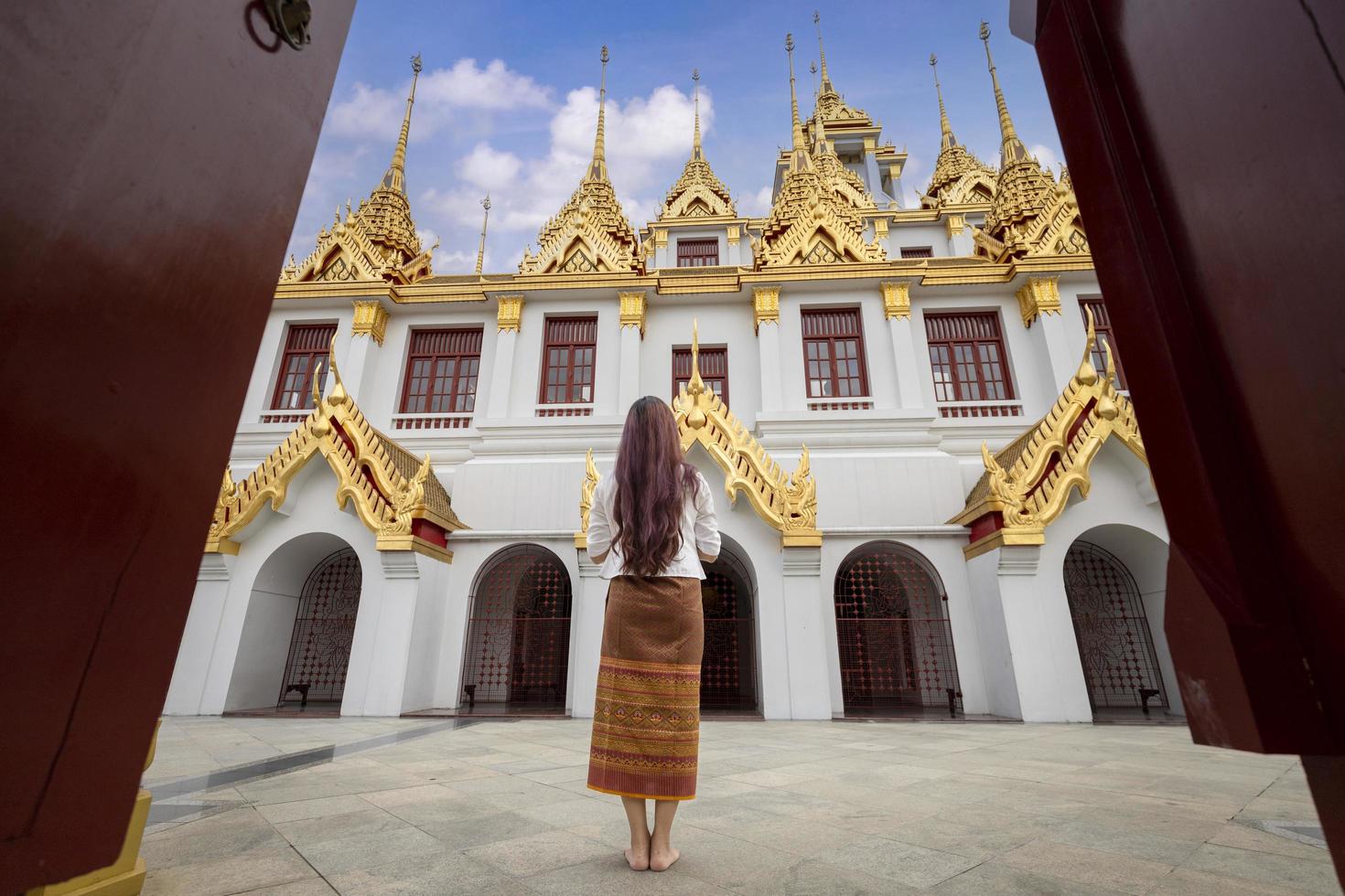 buddhistisk asiatisk kvinna gör promenader meditation runt templet för fred och lugn religion praktiken koncept foto