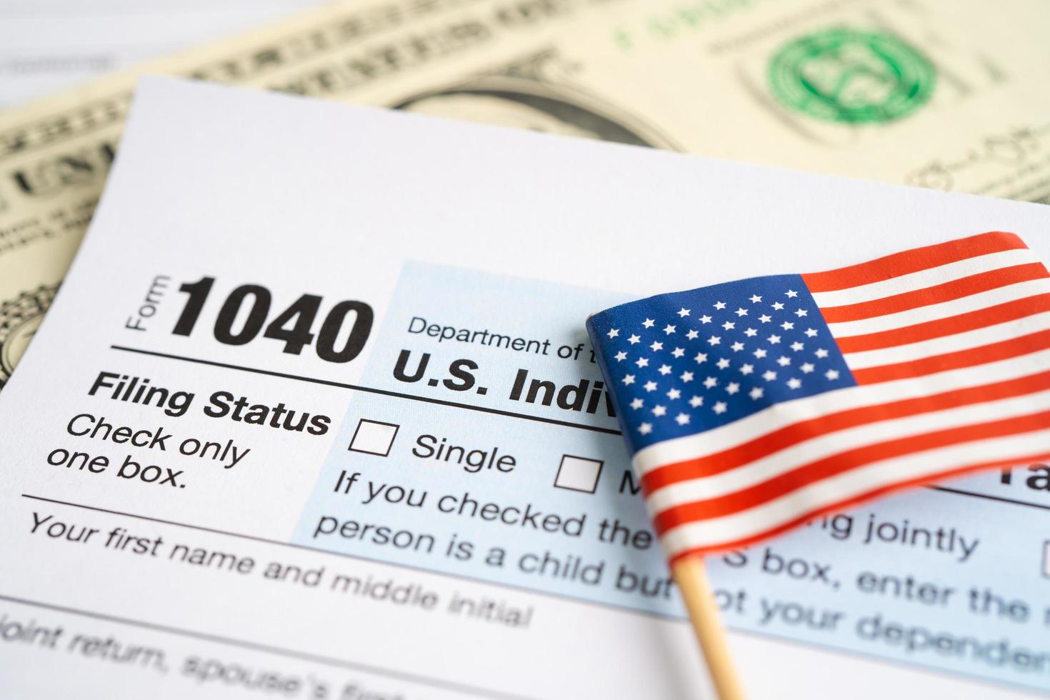 skattedeklaration blankett 1040 med usa america flag och dollarsedel, us individuell inkomst. foto