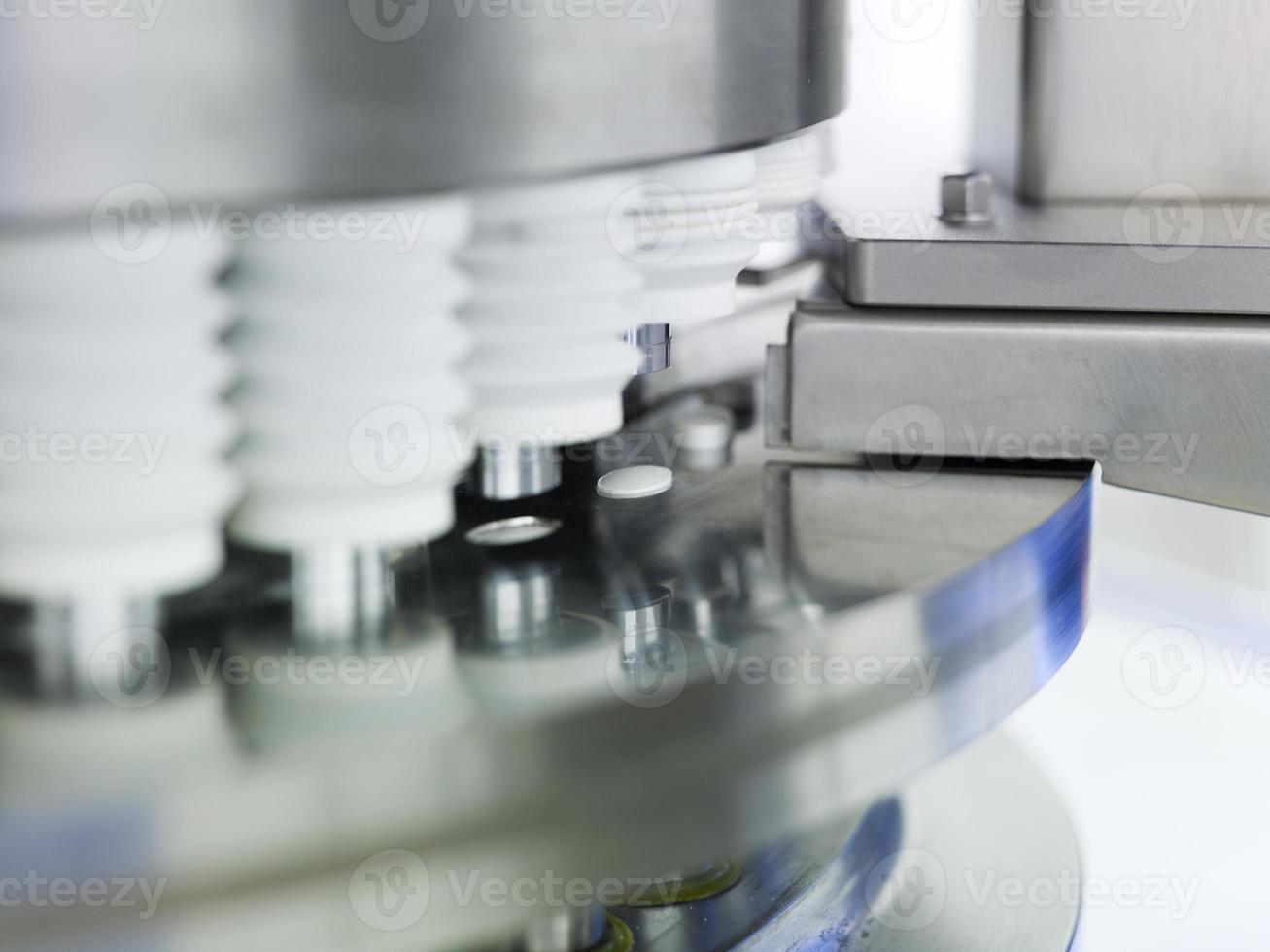 närbild av piller som formas i en steril maskin foto