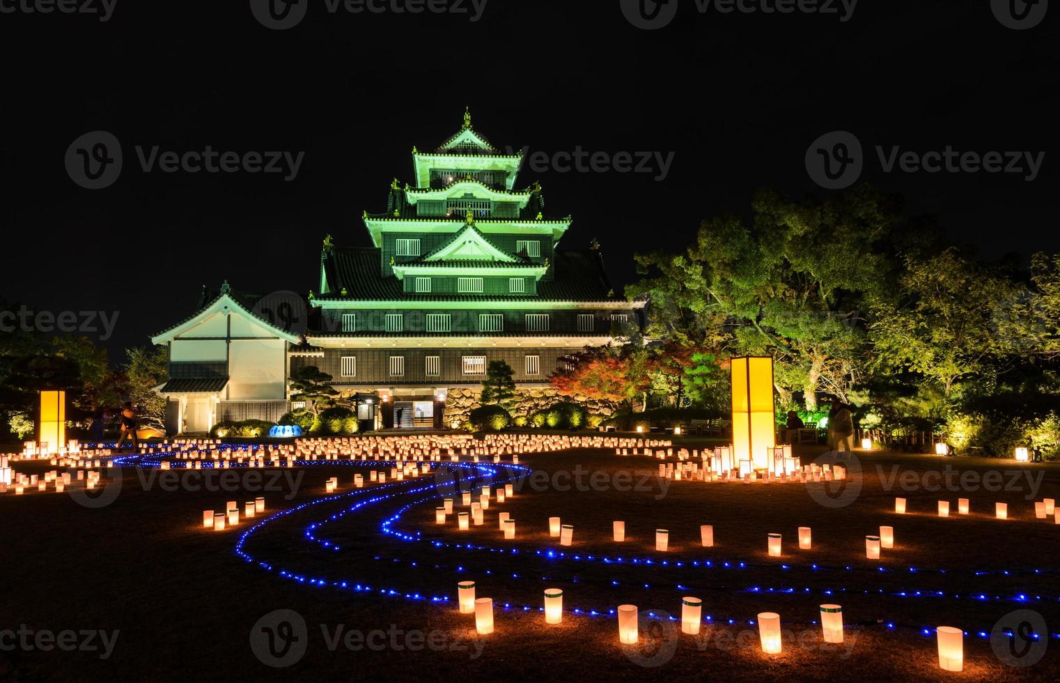 okayama slott med lyktor som lyser upp på natten i okayama, japan foto