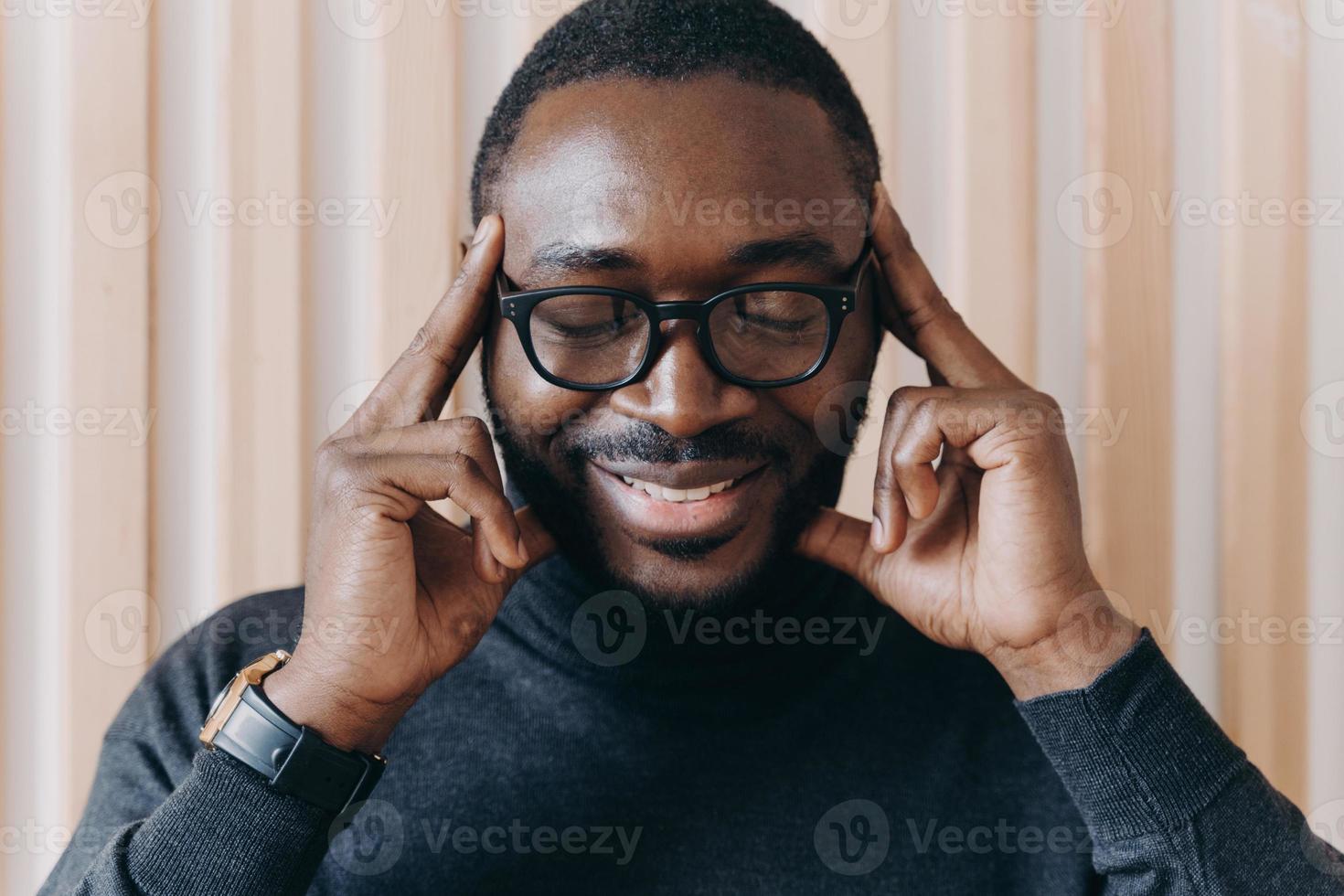 tankeväckande afrikansk amerikansk manlig entreprenör med slutna ögon vidrör tinningar med pekfingrar foto