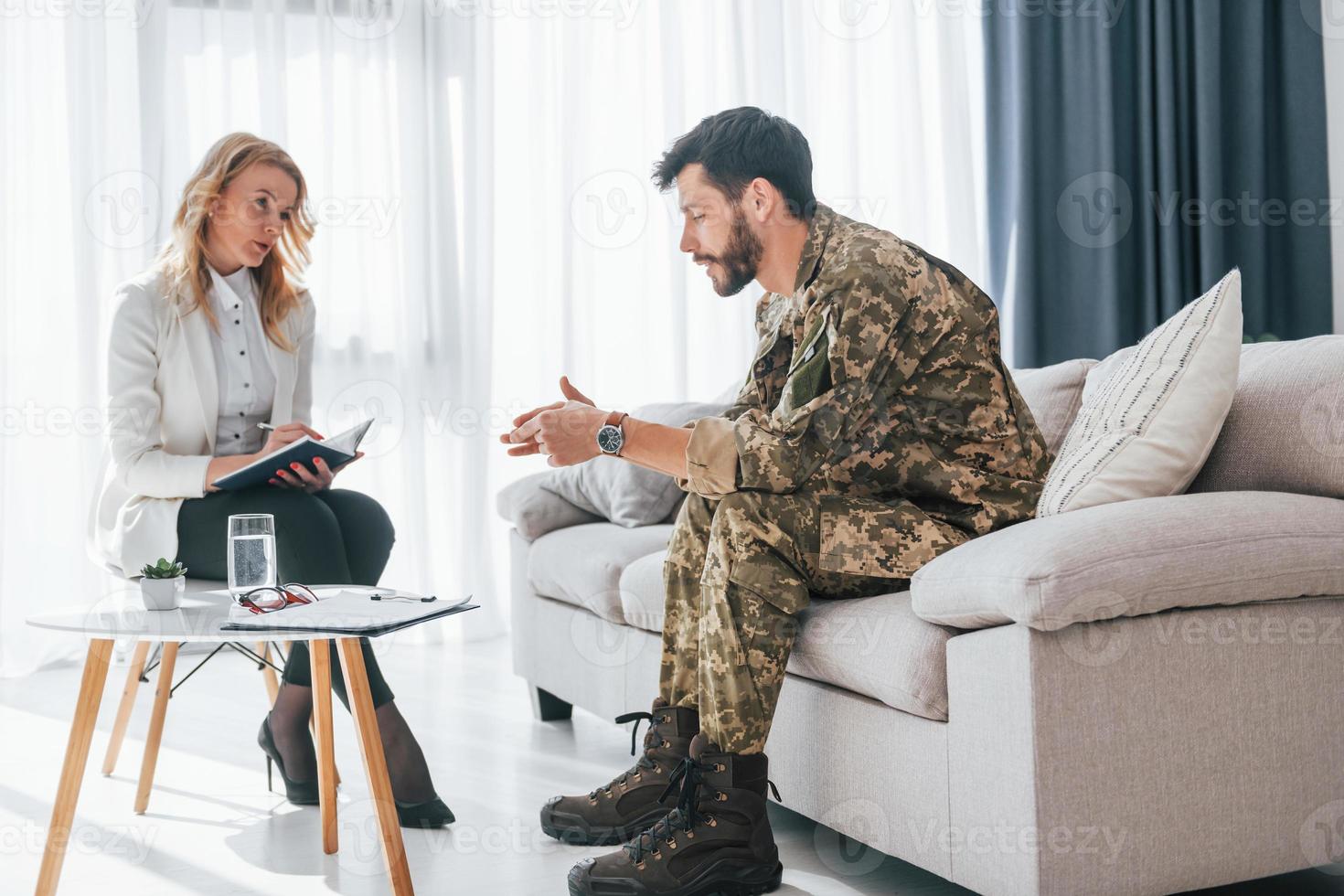 sidovy. soldat har terapisession med psykolog inomhus foto