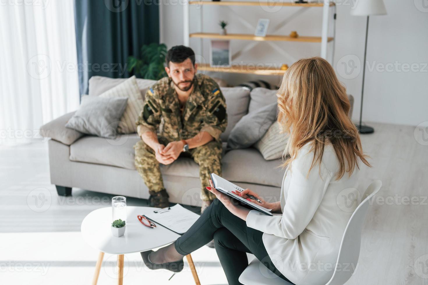 föra konversation. soldat har terapisession med psykolog inomhus foto