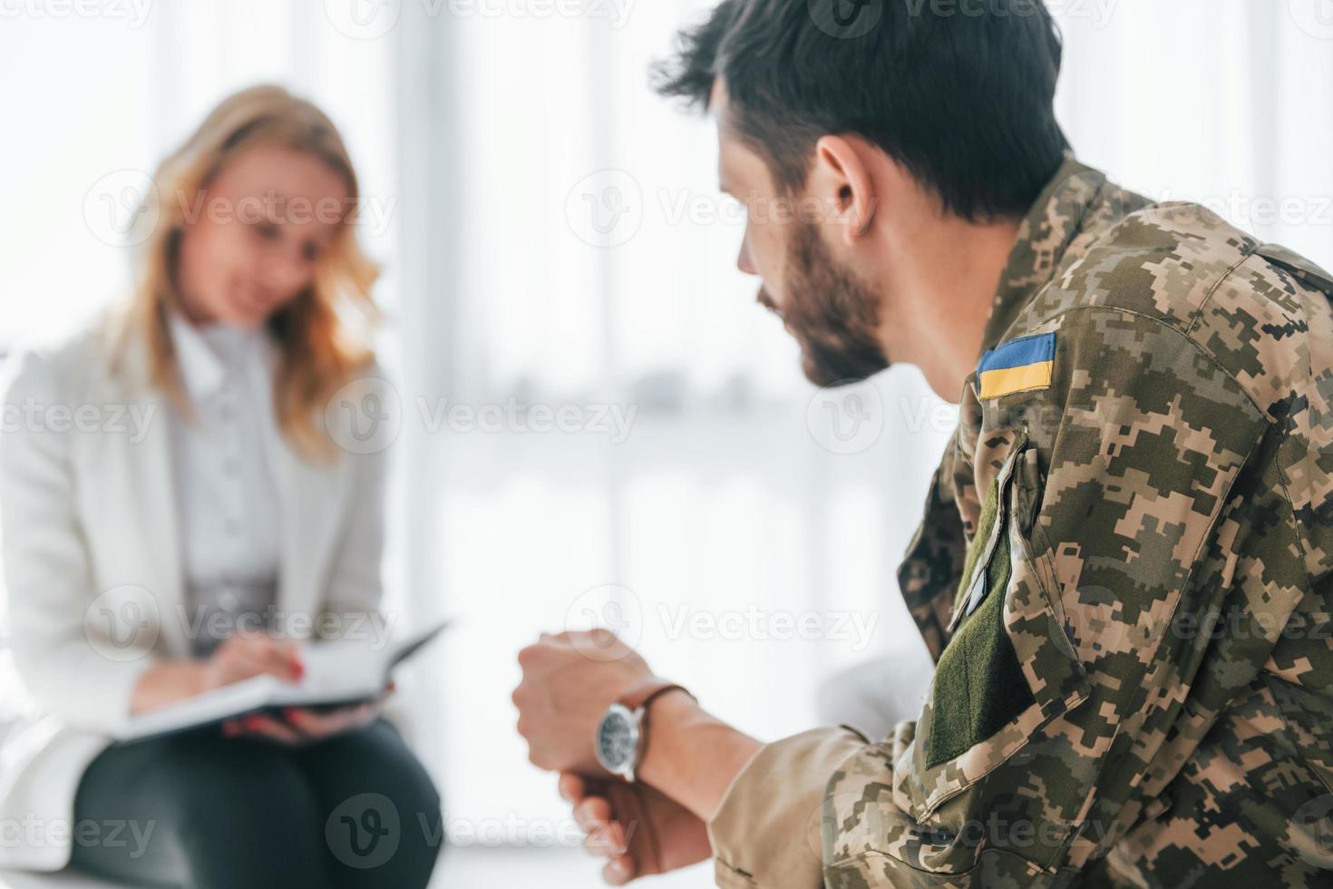 sidovy. soldat har terapisession med psykolog inomhus foto